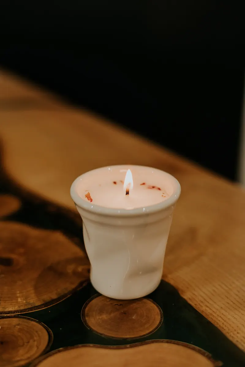 Bougie parfumée allumée dans un verre torsadé, ambiance chaleureuse à la maison